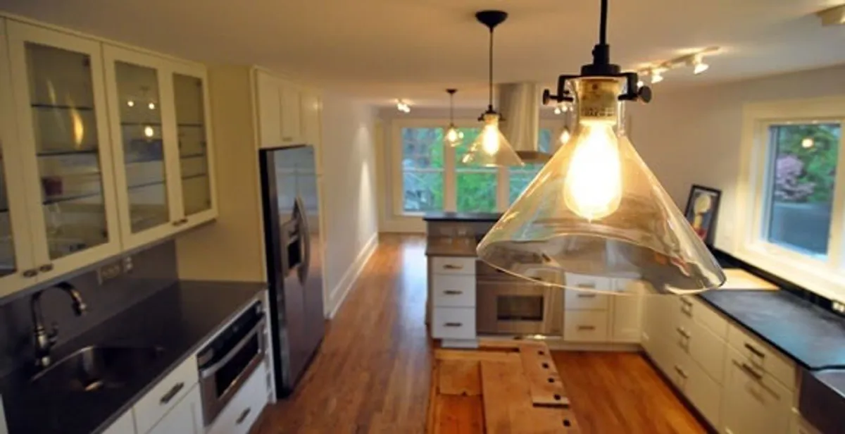 Residential electrician installing modern indoor light fixture in a home in Bellevue, NE